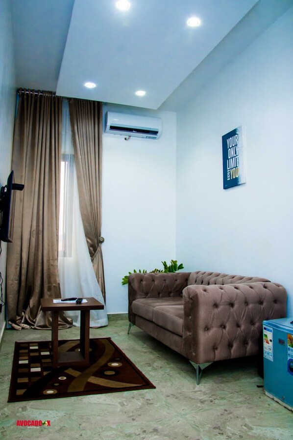 A modern living room with a brown sofa, a small table, and a blue cabinet. - Avocado X Kubwa (Abuja)