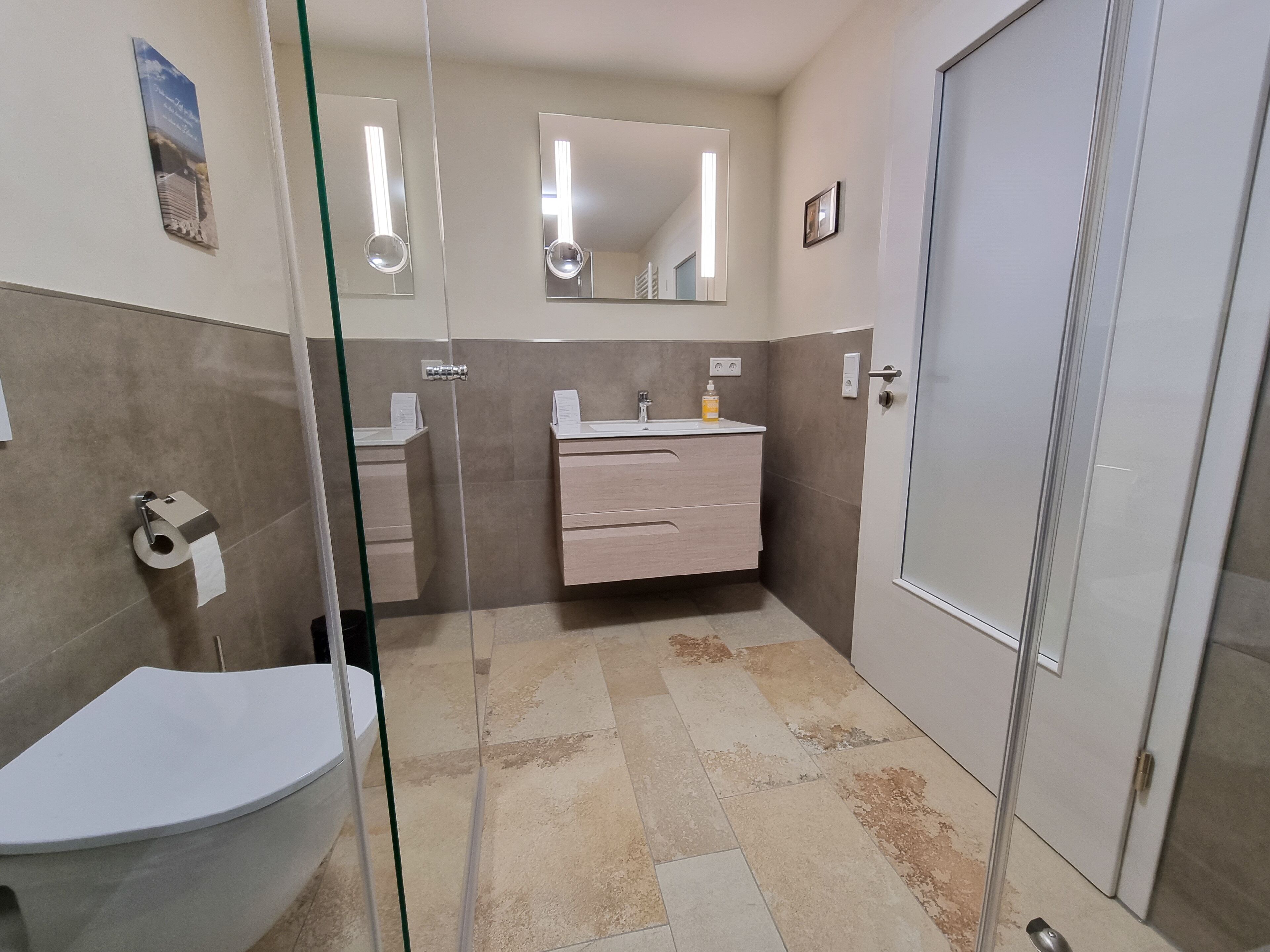 Un baño con inodoro, lavamanos, tocador y espejo.