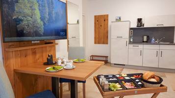 Eine moderne Küche mit weißen Schränken, einem Holztisch und einem Frühstücksbuffet.