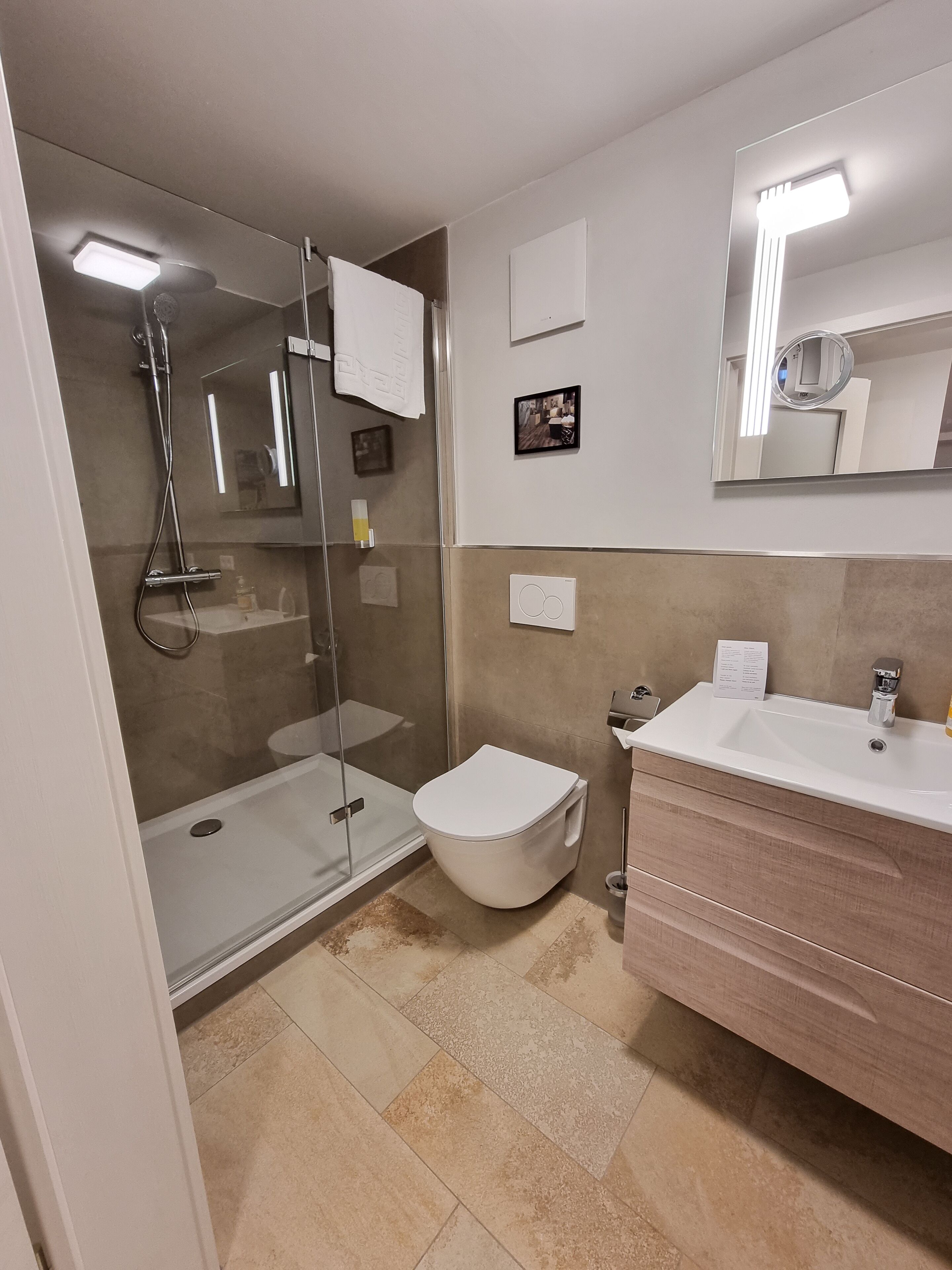 Ein modernes Badezimmer mit einer Duschkabine, einer Toilette und einem Waschtisch.