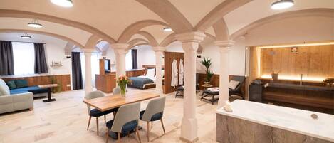 A spacious living area with a dining table, seating, and a reception desk.