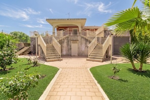 A house with a central staircase, a paved entrance, and a well-maintained garden. - Villa With Volcano View (Zafferana Etnea)