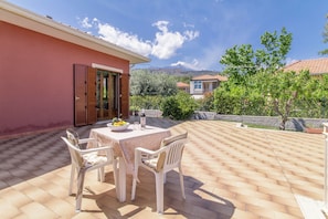 An outdoor patio with a table and chairs, a view of the surrounding neighborhood, and a clear sky. - Villa With Volcano View (Zafferana Etnea)