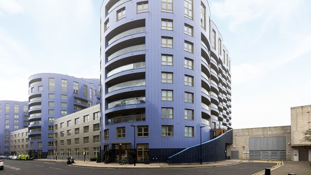 A modern multi-story building with a curved facade, large windows, and balconies. - The Islington Collection (London)
