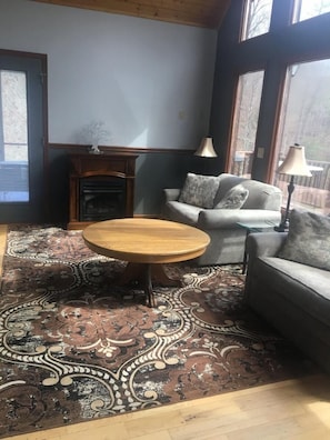 Cozy living room with a fireplace, round coffee table, and plush sofa.