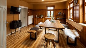 A wooden interior with a central dining table, benches, a bar area, and a television on the wall. - Time-out house Edertal for up to 9 people (Edertal)
