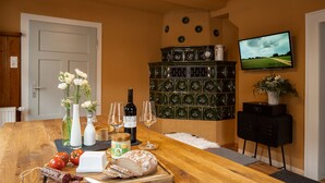 A wooden dining table with food items, wine, and glasses. A television is mounted on the wall. - Time-out house Edertal for up to 9 people (Edertal)