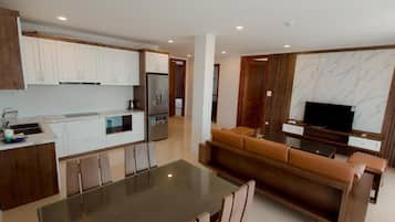 Deluxe Quadruple Room | Living area | 40-inch LED TV with cable channels, TV