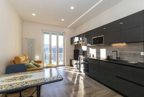 A modern apartment with a kitchen, dining area, and a sofa.