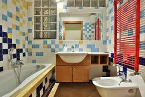 Un baño con bañera, lavamanos y bidé.