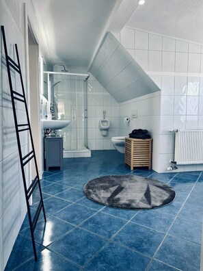 Un baño moderno con ducha, inodoro y lavamanos.