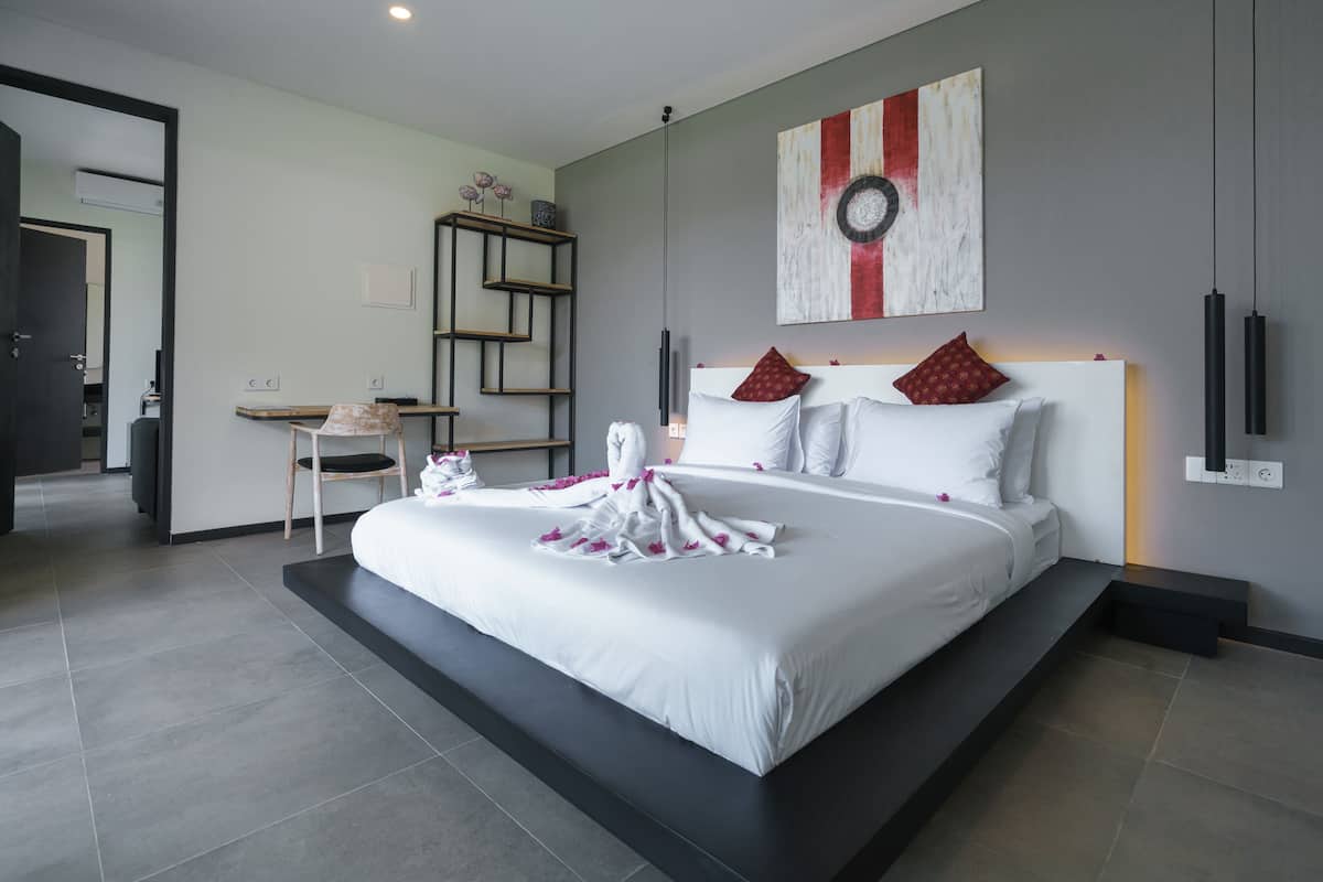 Una habitación de hotel moderna con una cama grande, un escritorio y una silla.
