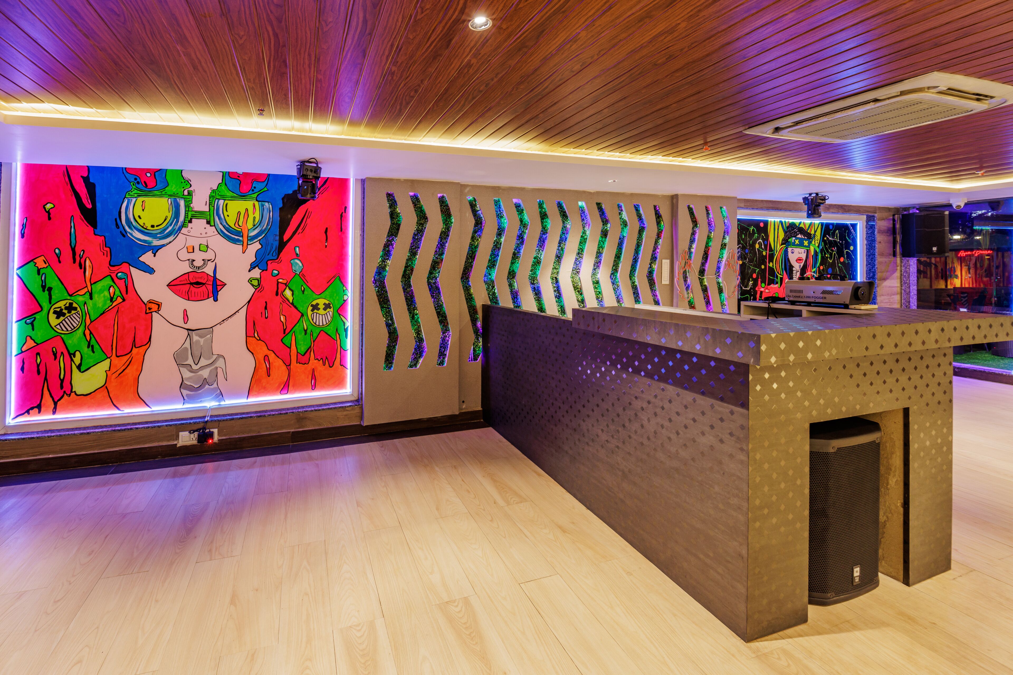 A reception area with a colorful mural, a modern reception desk, and a wooden ceiling.