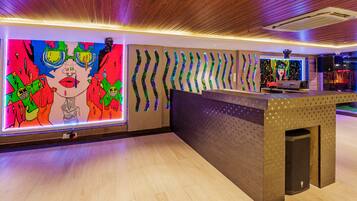 A reception area with a colorful mural, a modern reception desk, and a wooden ceiling.