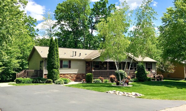 A two-story house with a stone foundation, a front porch, and a well-maintained lawn. - Moonlight View @ Spring Brook Resort (Wisconsin Dells)