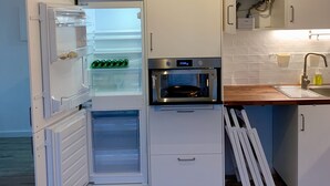 Une cuisine de taille réduite équipée d’un réfrigérateur, d’un four et d’un four à micro-ondes.