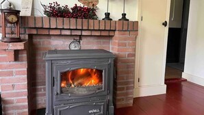 A fireplace with a brick mantel, a clock, and decorative birds. - Characteristic farmhouse on the dike (Andijk)