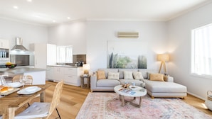 Un appartamento moderno con cucina, zona pranzo e soggiorno.