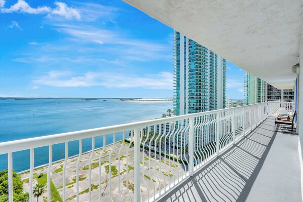 A balcony with a view of the ocean and tall buildings.