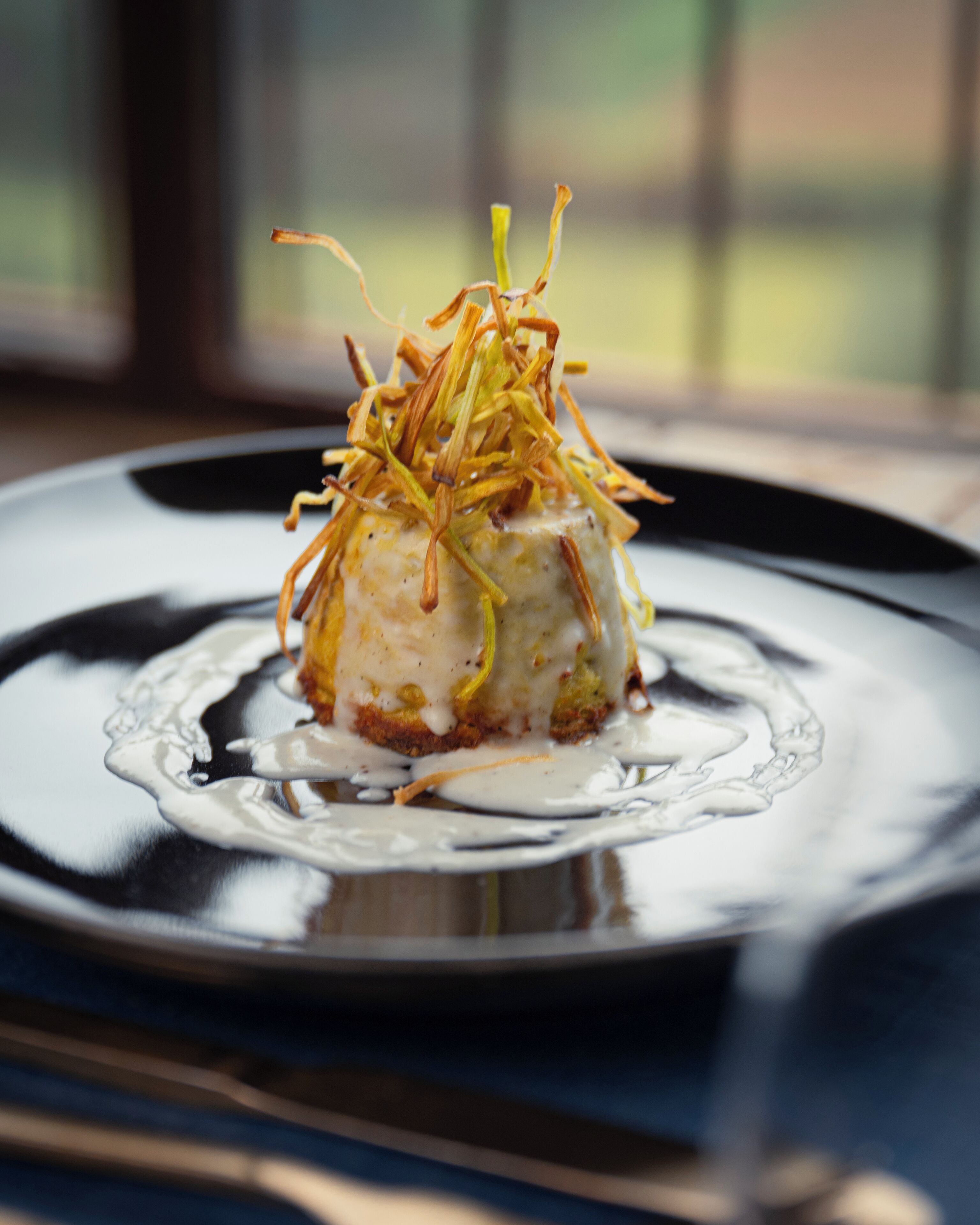A dessert on a plate with a clear liquid around it.