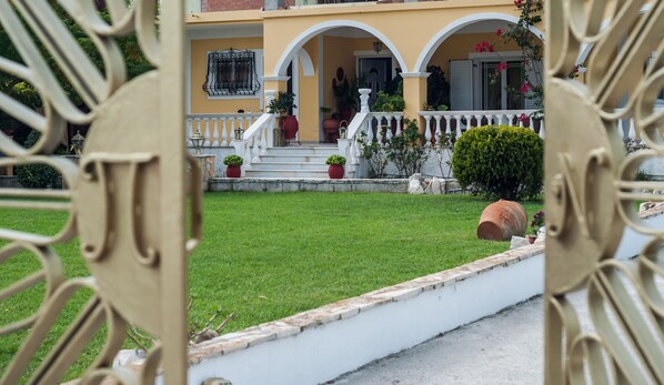 A yellow building with a white balcony and steps leading up to the entrance. - La Casa Di Nina (Zakynthos)
