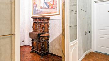 Un pasillo interior con un mueble de madera, una puerta y un cuadro en la pared.
