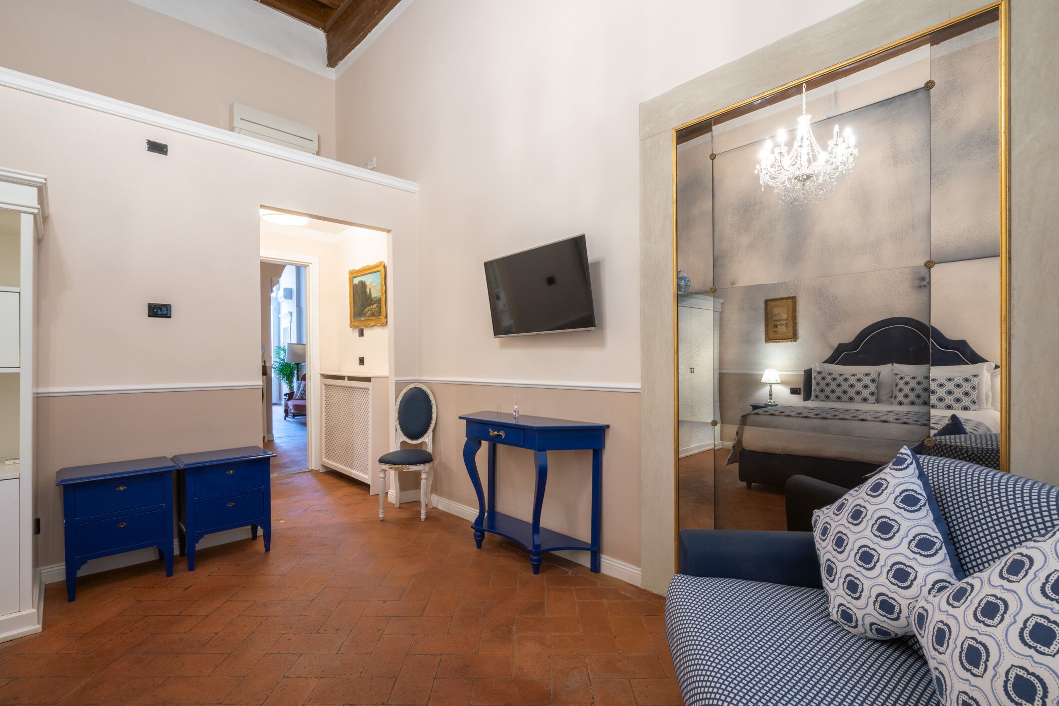 Una habitación con cama, escritorio, silla y sofá azul.