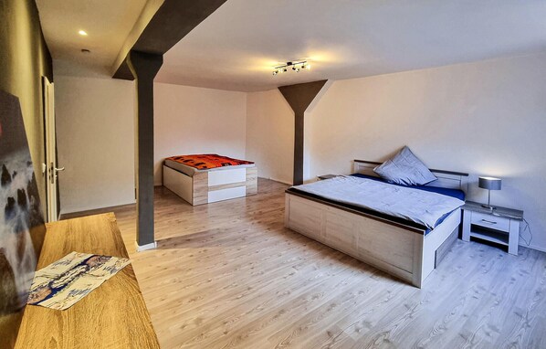 Een moderne slaapkamer met een bed, nachtkastje en een klein bureau.