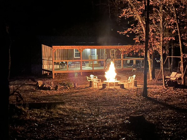 A cabin with a fire pit and outdoor seating area.