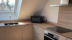 A modern kitchen with a built-in microwave, oven, and sink. - New: 2-bedroom apartment in luxury residence. (Ribeauvillé)