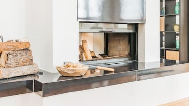 A modern kitchen with a large stainless steel range hood, wooden countertops, and a herringbone wood floor. - Penthouse big apartment with Sauna (Vienna)