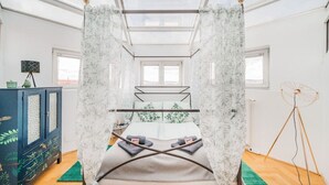 A bedroom with a canopy bed, a side table, a cabinet, and a floor lamp. - Penthouse big apartment with Sauna (Vienna)