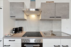 Uma cozinha moderna com fogão embutido, micro-ondas e pia.