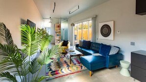 A modern living room with a blue sofa, a yellow armchair, and a colorful rug. - Private modern hideaway in downtown Albuquerque. (Albuquerque)