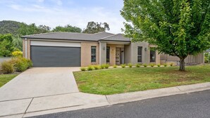 A single-story house with a dark garage door, a small front porch, and a well-maintained lawn.