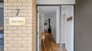 A hallway with a brick wall and a door labeled "TROIS VÉLOS".