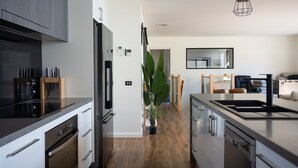 Une cuisine moderne dotée d’appareils électroménagers en acier inoxydable, de meubles en bois et d’un îlot central.