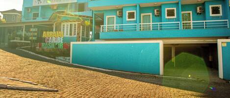 Un edificio de dos pisos con fachada azul, un letrero que dice "PONSA DA MURGUE" y un anuncio para "ARRIOLA CARIBE BASILICIR".