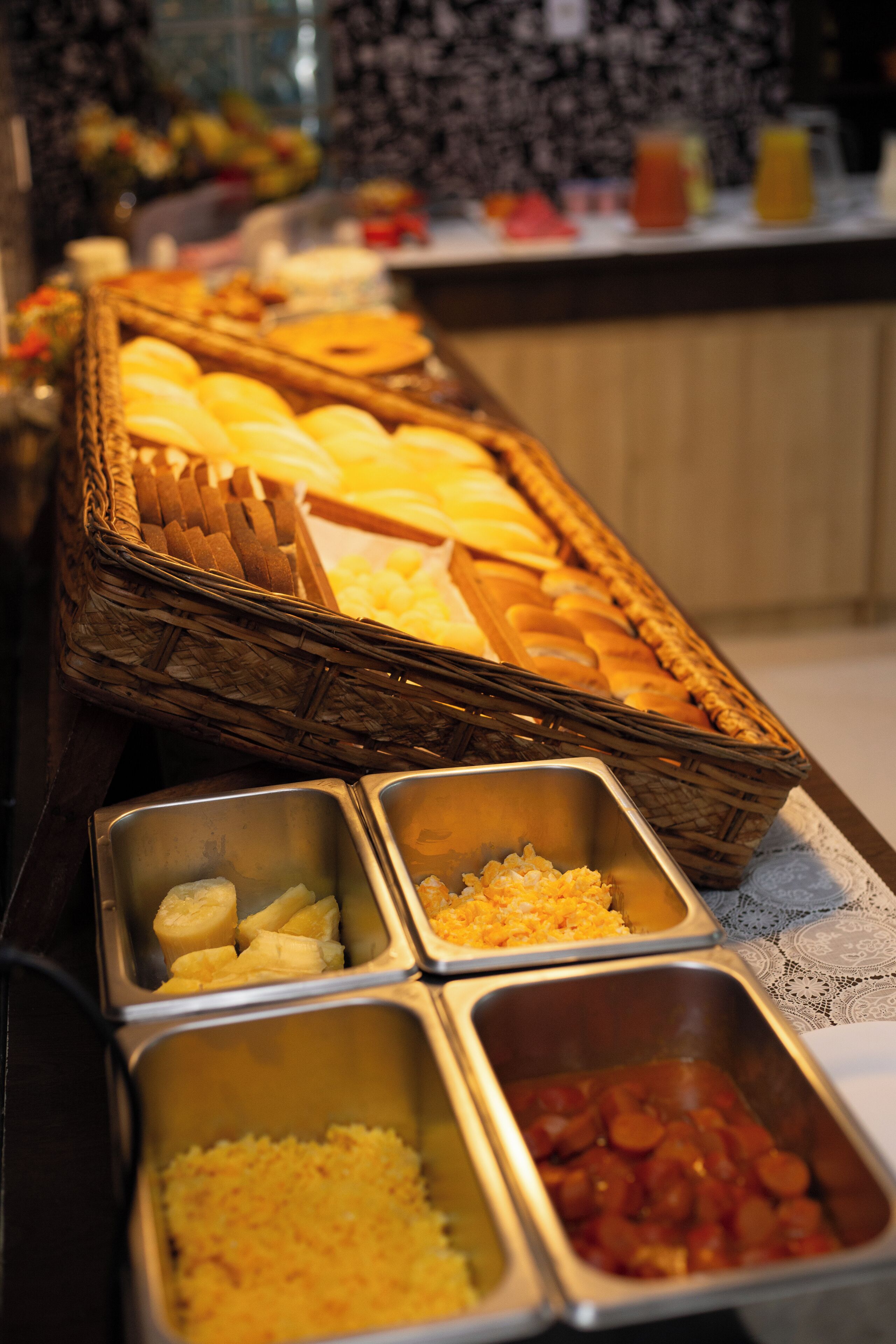 A buffet with various food items including bread, fruits, and prepared dishes.
