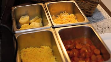 A buffet with various food items including bread, fruits, and prepared dishes.