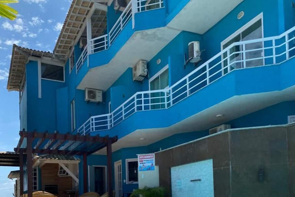 Une piscine avec un bâtiment bleu en arrière-plan.