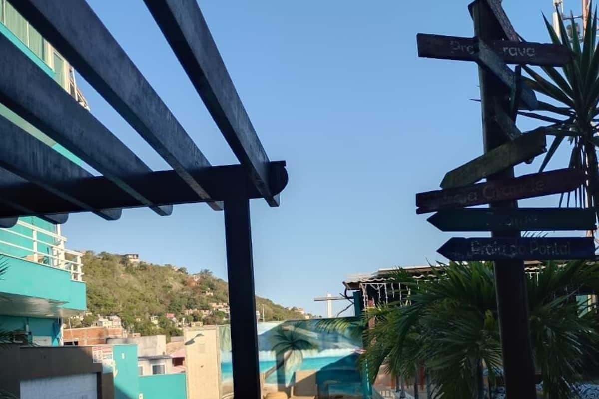 Un espace piscine avec vue sur une colline, une pergola et un panneau indicateur.