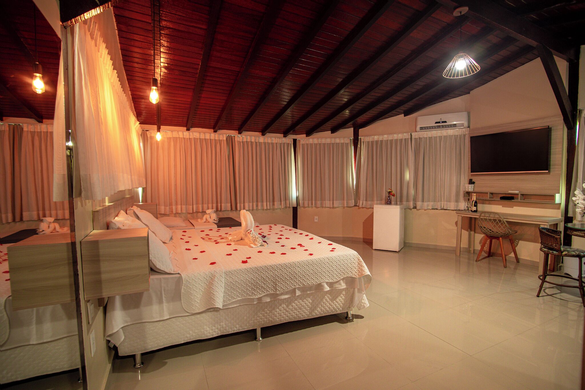 A bedroom with a bed, bedside tables, a desk, and a chair.