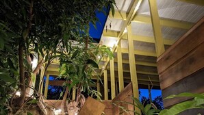 A wooden structure with a naturalistic design, featuring a rock formation and lush greenery.