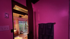 Een kamer met een spiltrap, een witte vachtkleed en een paarse wand.