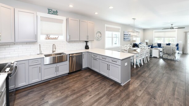 A modern kitchen with white cabinets, stainless steel appliances, and a wooden floor. - 5 BR Beach House with a Private Pool! Grace's Places "FKA Blessed in Waves" (Surfside Beach)