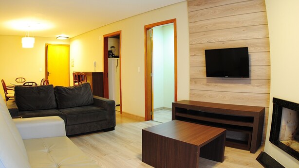 Una sala de estar con sofá, mesa de centro, televisor y chimenea.