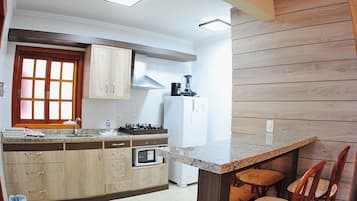 Apartamento 105 | Cocina privada | Refrigerador, microondas y utensilios de cocina