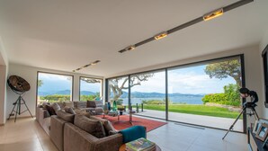 A modern living room with a large sofa, a small table, and a tripod. - Nice villa completely renovated (Gassin)