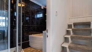 A modern bathroom with a glass shower enclosure, a bathtub, and a wooden floor. - Rivage - Two Bedroom Cottage, Sleeps 4 (Deganwy)